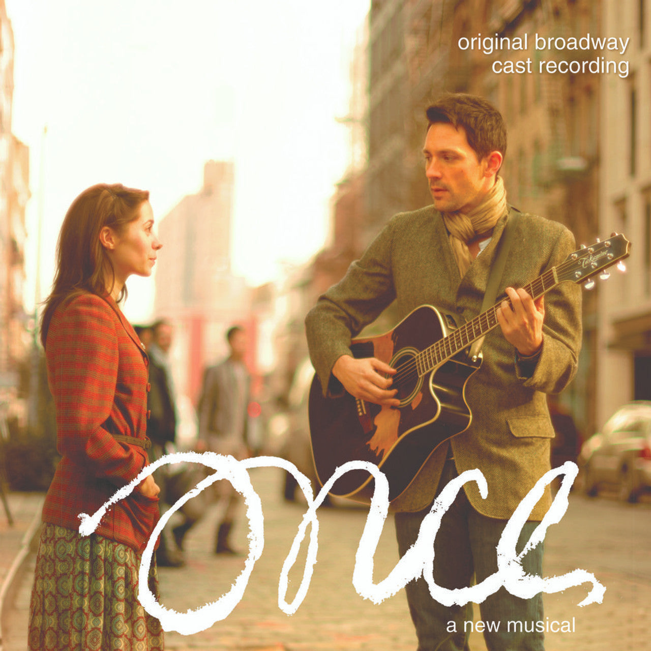 Cover art for the original Broadway cast recording of the musical 'ONCE', featuring a man and a woman on a city street, with the man playing a guitar.